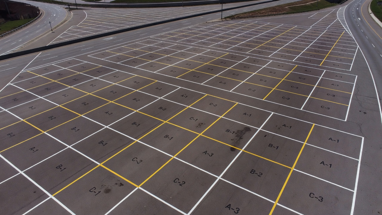 Vue aérienne d'un réseau routier montrant des sections de chaussée avec des limites d'unités d'échantillonnage marquées pour le relevé de l'état, organisé pour l'évaluation PCI selon l'ASTM D6433