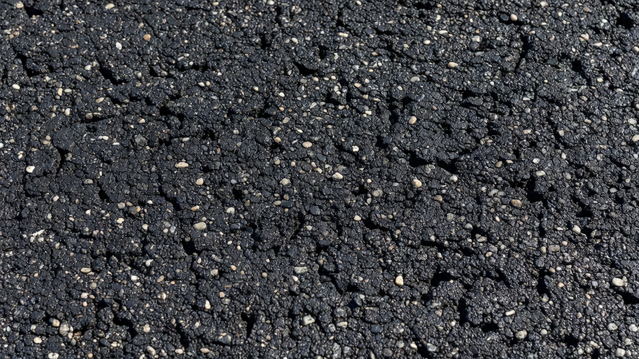 Vue texturée en gros plan de la surface d'un slurry seal durci montrant la matrice de granulats fins et la texture antidérapante