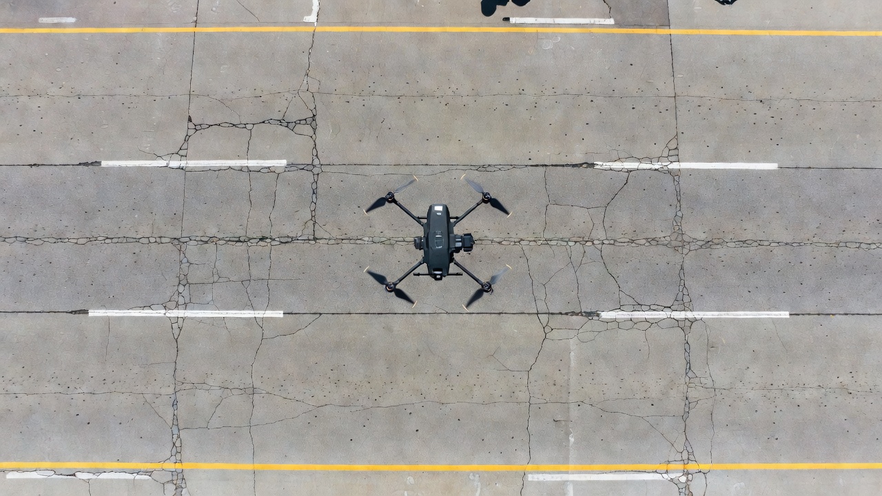 Vue nadir aérienne d'une inspection de chaussée autoroutière par photogrammétrie drone montrant les fissures et dégradations de surface pour l'évaluation du génie civil