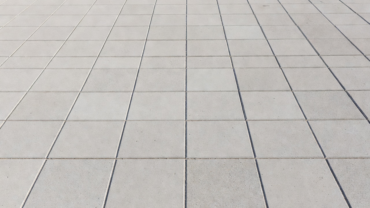 Gros plan des joints sciés dans un revêtement de whitetopping en béton formant un motif de panneaux carrés