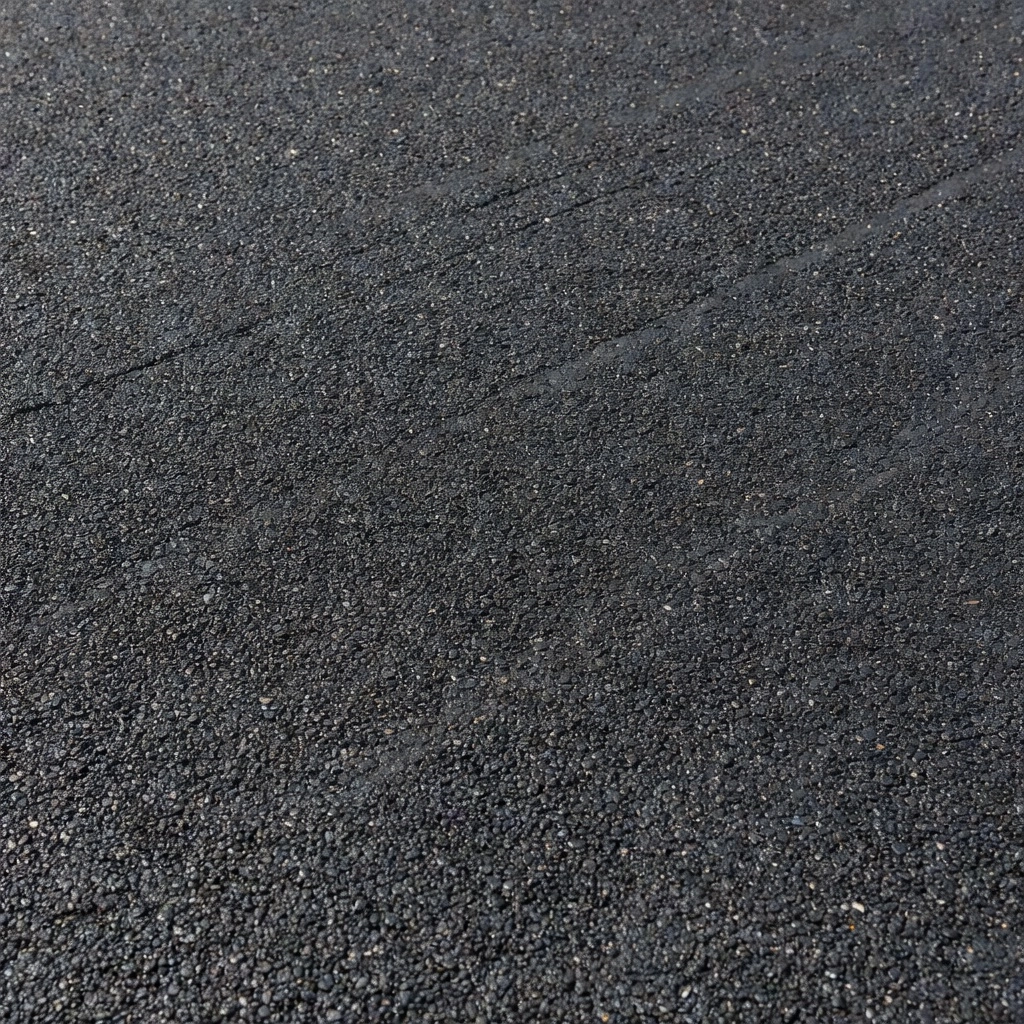 Textura de cerca del microsurfacing curado mostrando la matriz de agregado triturado y la superficie resistente al deslizamiento