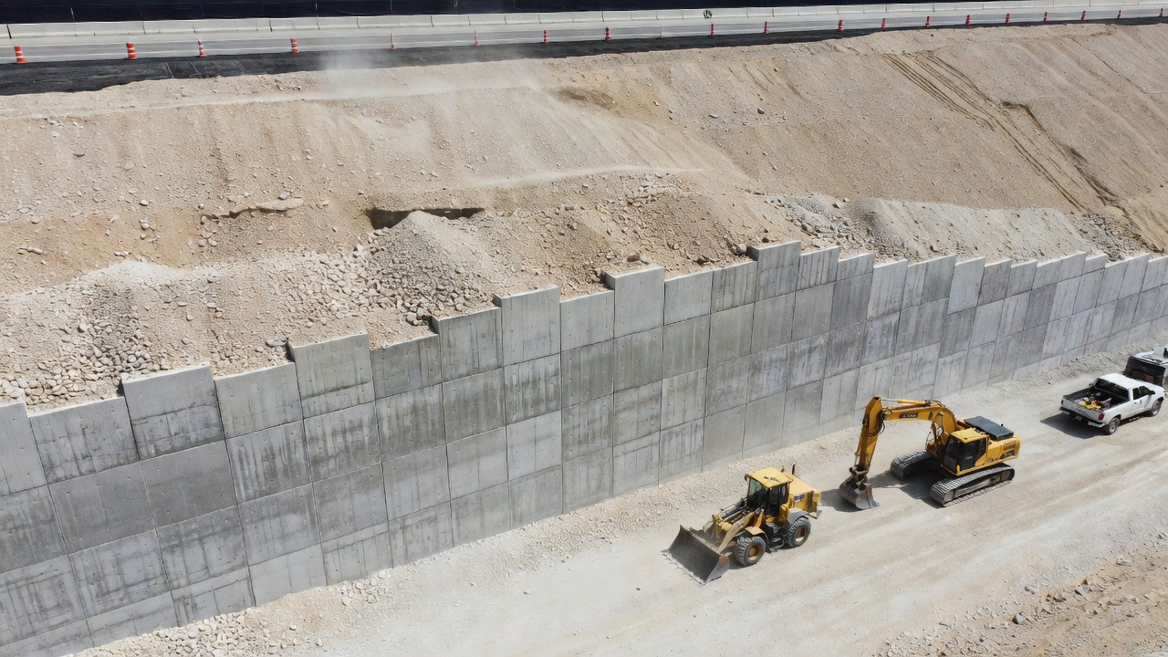 Große mechanisch stabilisierte Erdstützmauer (MSE) mit vorgefertigten Betonverkleidungsplatten zur Stützung eines Autobahndamms während der Bauphase